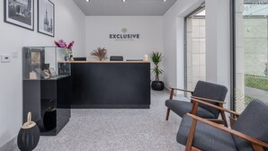 Ein Empfangsbereich mit modernem Design, ausgestattet mit einer Rezeption, einer Sitzgruppe und gerahmten Bildern an der Wand.