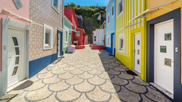 A narrow alleyway with colorful buildings, each with a distinct door number. - Maredimo Village casa 2 (Porto)