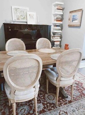 Enjoy meals in this cozy dining area with a wooden table and comfortable seating for four.