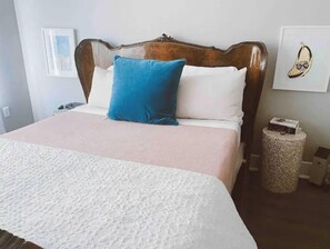 Cozy retreat with a large bed, white bedspread, and a wicker basket.