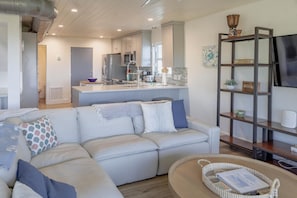 A modern living room with a sofa, a coffee table, and a bookshelf. - Spacious 3BR townhome w/ easy beach & pool access (Siesta Key)