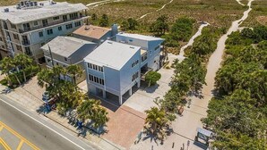 A coastal hotel with a modern design, featuring a large building with multiple windows and a flat roof.