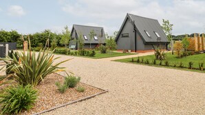 Une maison moderne avec une allée en gravier et un jardin bien entretenu.