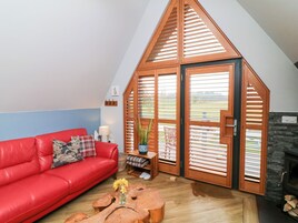 Un salón acogedor con un sofá rojo, una mesa de centro de madera y una chimenea.