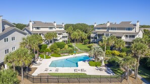 A residential complex with a swimming pool, multiple balconies, and lush landscaping. - Seagrove Villa 11C - Extreme Oceanfront! Resort! (Isle of Palms)