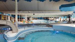 An indoor swimming pool with a curved design, a covered roof, and a slide. - RBR 232 - Beach Resort Kamperland (Kamperland)