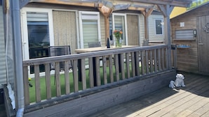 A covered deck with a wooden railing, a table, and chairs. - RBR 232 - Beach Resort Kamperland (Kamperland)