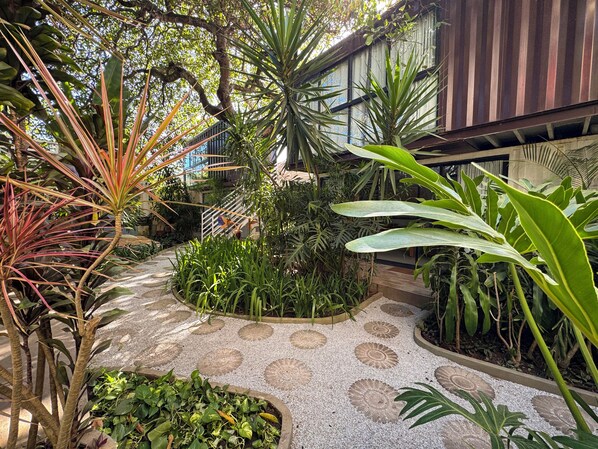 A garden with various plants and a patterned stone pathway.