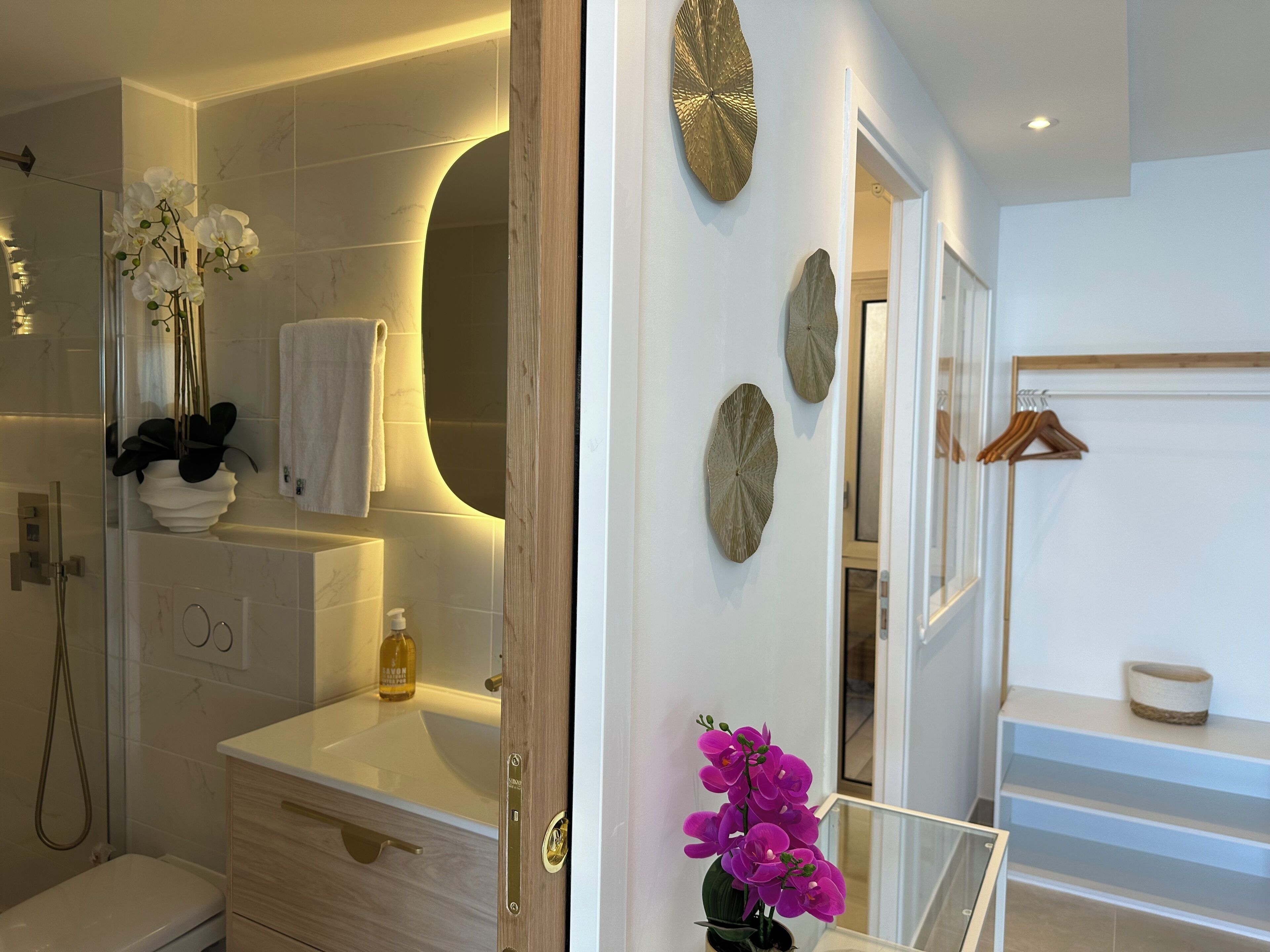 A modern bathroom with a glass shower enclosure, a vanity with a sink, and a mirror.