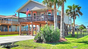 A two-story house with a balcony, a flag, and palm trees. - Beautiful island paradise only 6 blocks to the beach (Galveston)