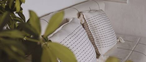 A room with a mural of a surfer on a wave, a window with a grid pattern, and a bed with a striped pillow.