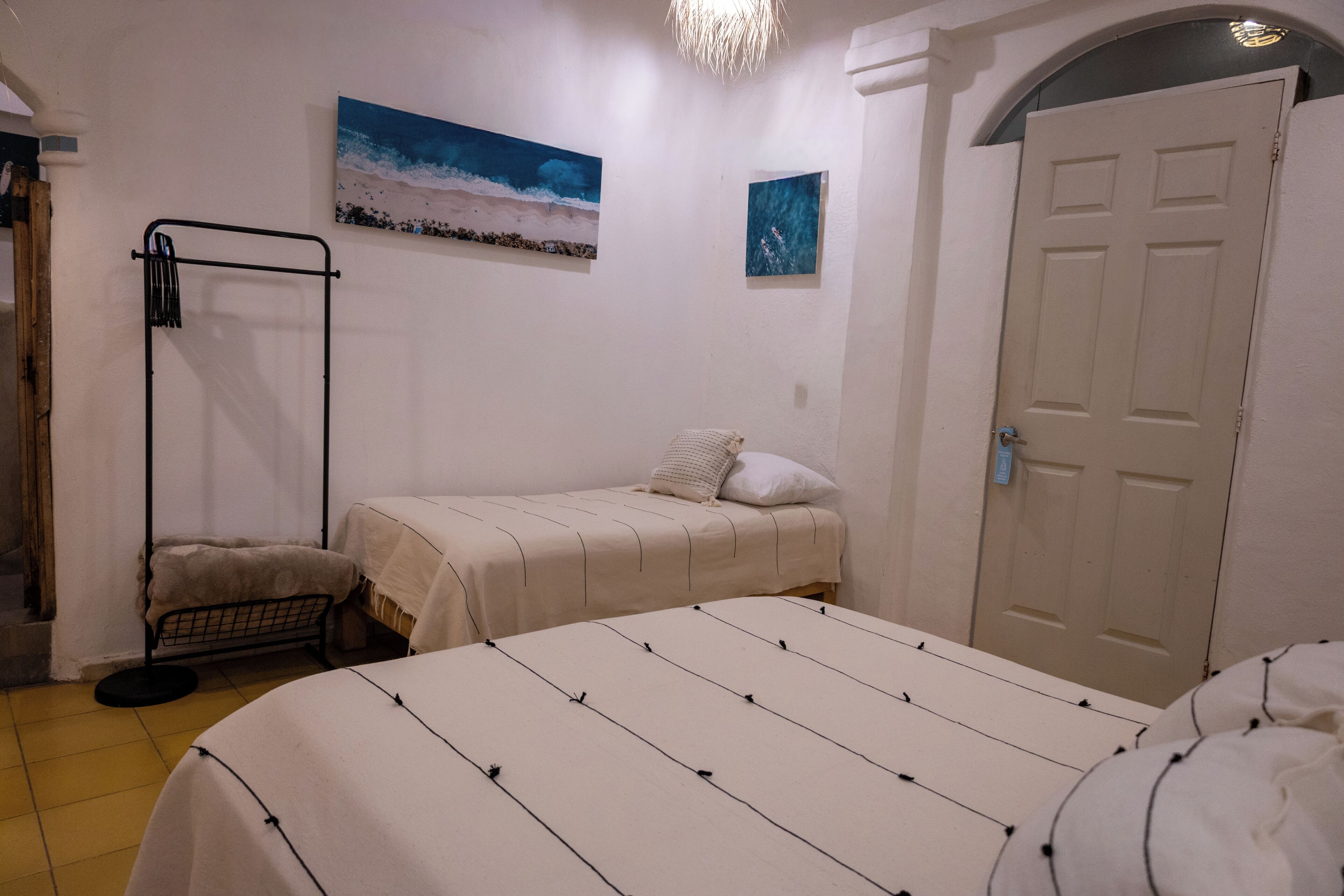 Een slaapkamer met een bed, een klein nachtkastje, een wandrek en een deur.