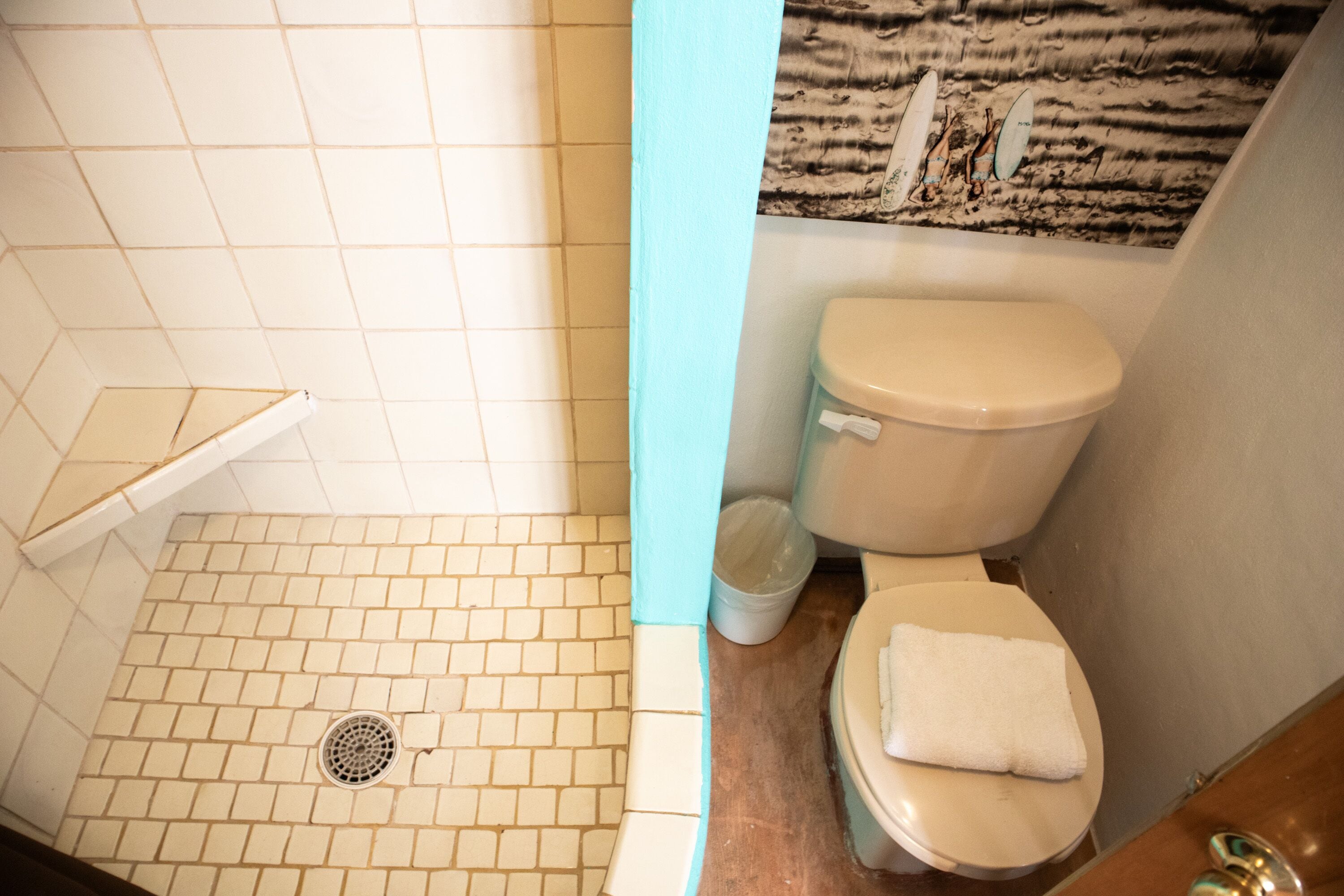 Une salle de bain avec une douche carrelée, des toilettes et un lavabo.