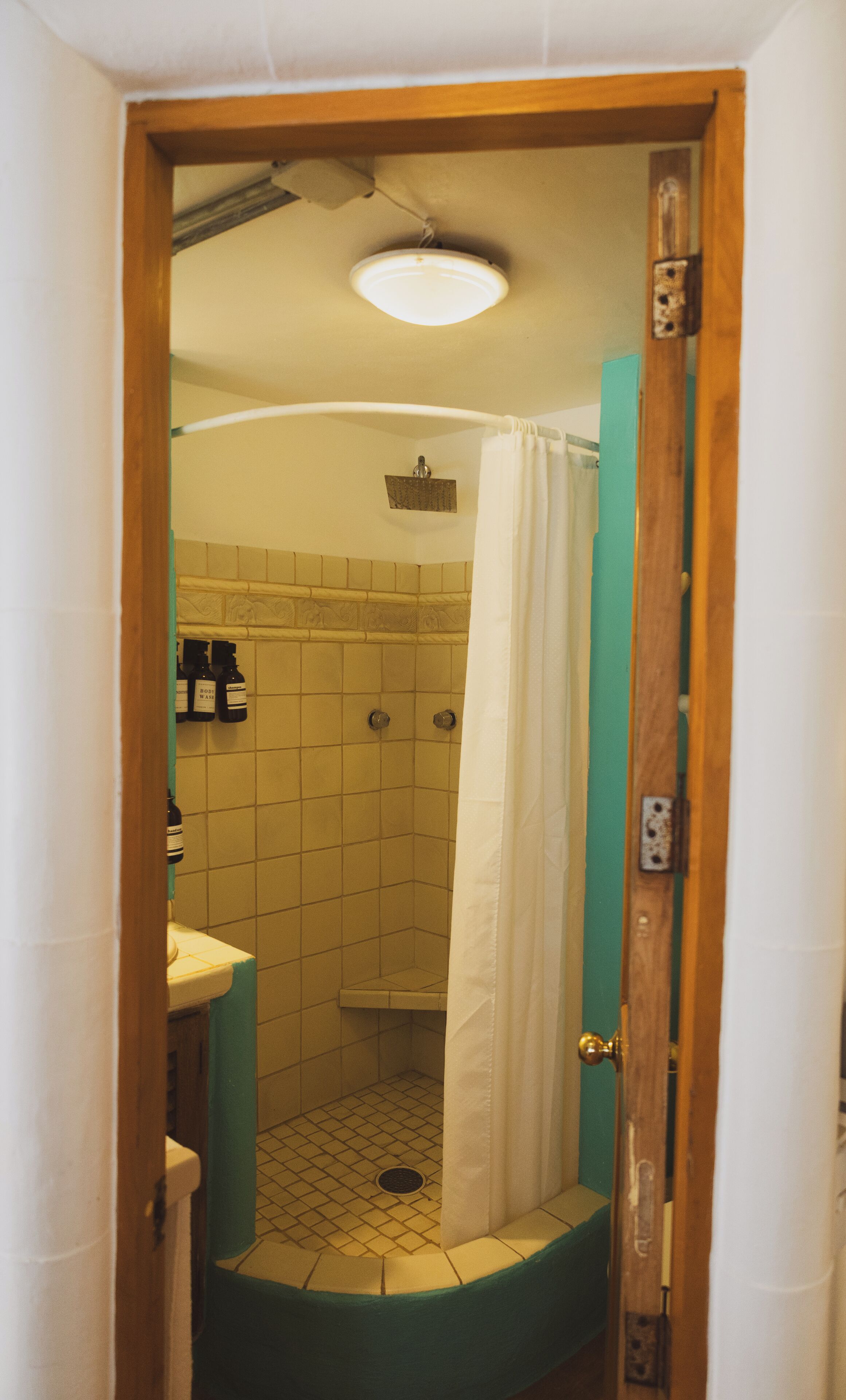 A small bathroom with a shower, a sink, and a toilet.