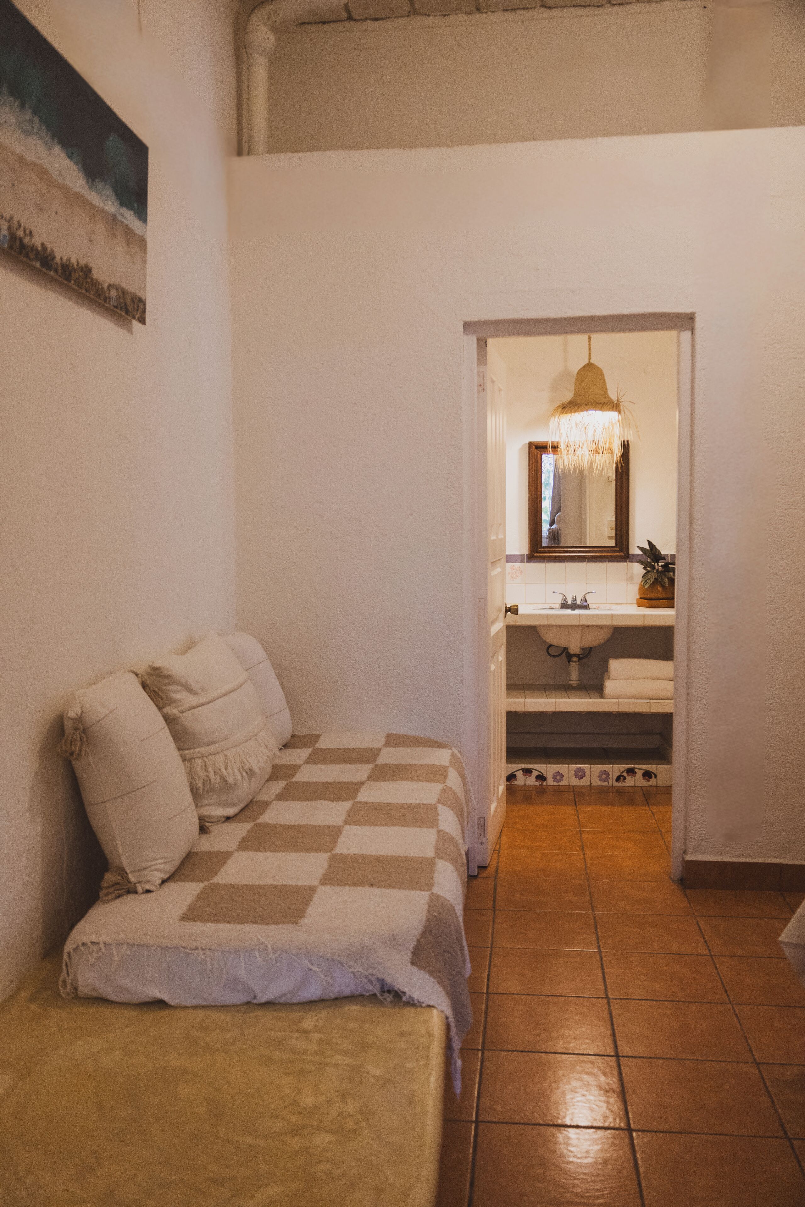 A bedroom with a checkered bedspread, a bedside table, and a nightstand.
