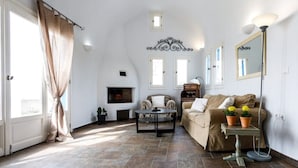 Una sala de estar con chimenea, un sofá, una mesa de centro y una lámpara.