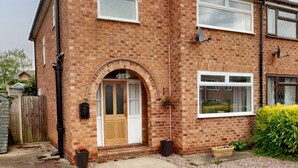 A two-story brick house with a front door, two windows, and a satellite dish. - The Hawthorns (Chester)