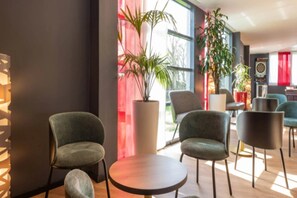 Un interior moderno con asientos, una planta grande en maceta y un dardo.