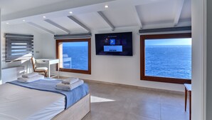 Un dormitorio moderno con una cama grande, un escritorio y una televisión.