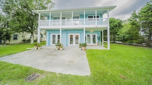 A two-story house with a balcony, a front porch, and a number '703' on the front wall.