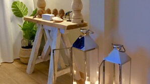Una mesa de madera con adornos, una planta en maceta y un espejo.