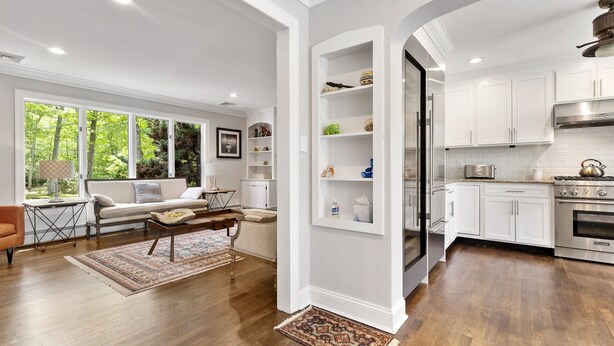 A modern kitchen with white cabinetry, a stainless steel range, and a built-in oven.