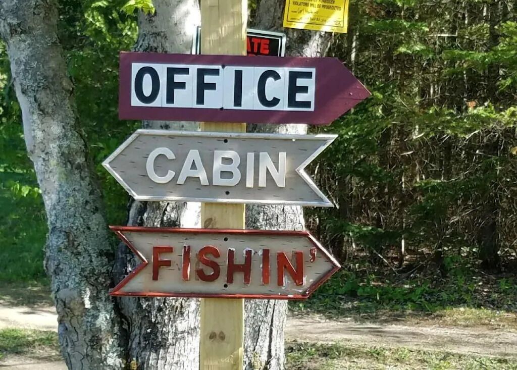 Directional signs for an office, cabin, and fishin' area.