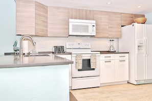 Enjoy cooking in this well-equipped kitchen with a large island, stainless steel range, and microwave.