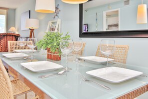Guests can dine in style with a beautifully set table and comfortable wicker chairs.
