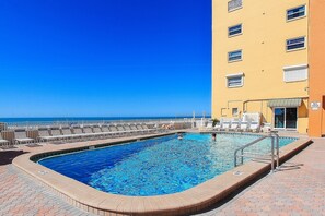 Relax by the pool with ocean views, surrounded by lounge chairs and umbrellas.
