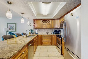Enjoy cooking in this fully equipped kitchen with a sink, refrigerator, and microwave, and dine at the adjacent table and chairs.