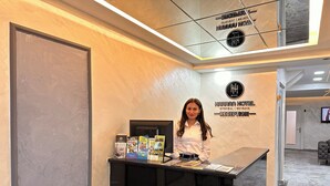 Bancada de recepção no HOTEL HARRAN em ISTANBUL, com uma mulher atrás dela.