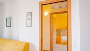 A room with a bed, a wardrobe, and two framed pictures on the wall. - Garda Orange Apartment (Desenzano del Garda)