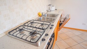 A kitchen with a gas stove, two sinks, and a dishwasher. - Garda Orange Apartment (Desenzano del Garda)