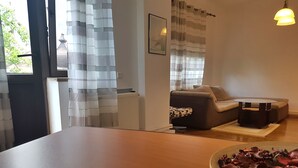 Ett modernt vardagsrum med en soffa, ett soffbord och ett matbord med en skål med mat på.