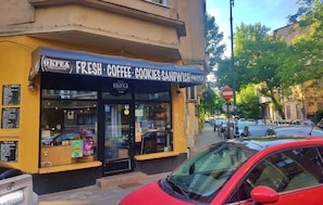 A coffee shop with a sign reading "Fresh Coffee, Cookies, Sandwich." - Spacious Apartment In The Centre Of The Capital (Bucharest)