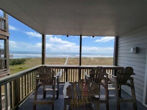 A covered porch with a view of the beach, wooden chairs, and a table. - I had to cancel my condo rental - You reap the Benefit of a DEEP DISCOUNT (Rodanthe)