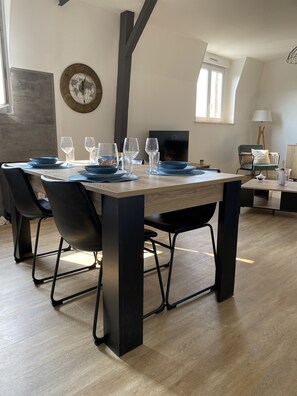 A dining area with a wooden table, black chairs, and a globe clock on the wall. - A spacious, elegant apartment in the heart of Epernay. Quiet top floor with a magnificent view. (Épernay)