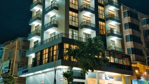 A multi-story hotel with illuminated balconies and a prominent sign at the top. - Kibo Palace Hotel Moshi (Moshi)