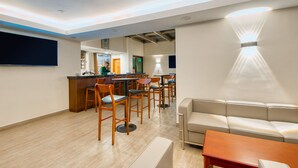 A modern hotel lobby with a reception desk, seating area, and a sofa. - Kibo Palace Hotel Moshi (Moshi)
