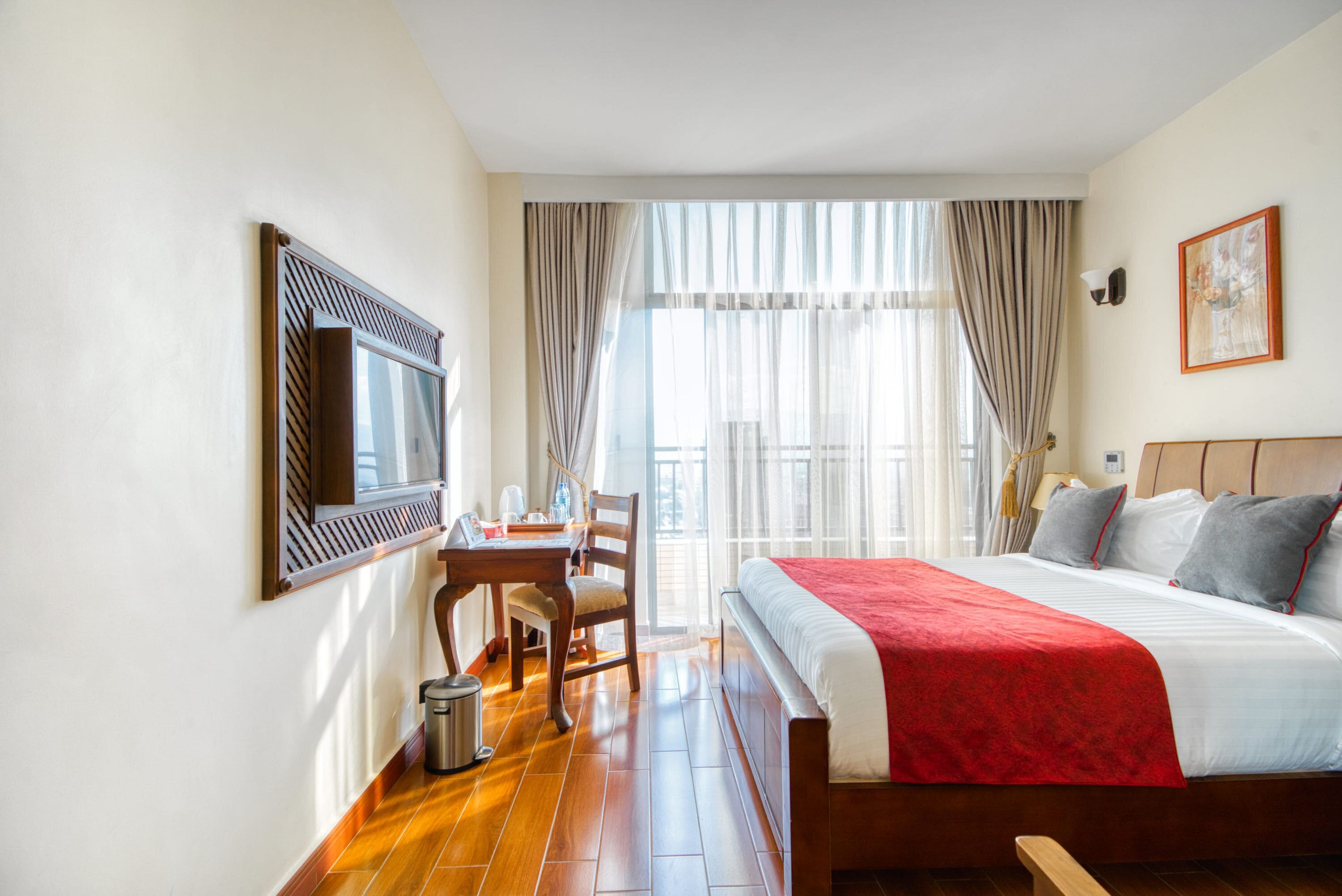 A hotel room with a bed, a desk, and a chair.