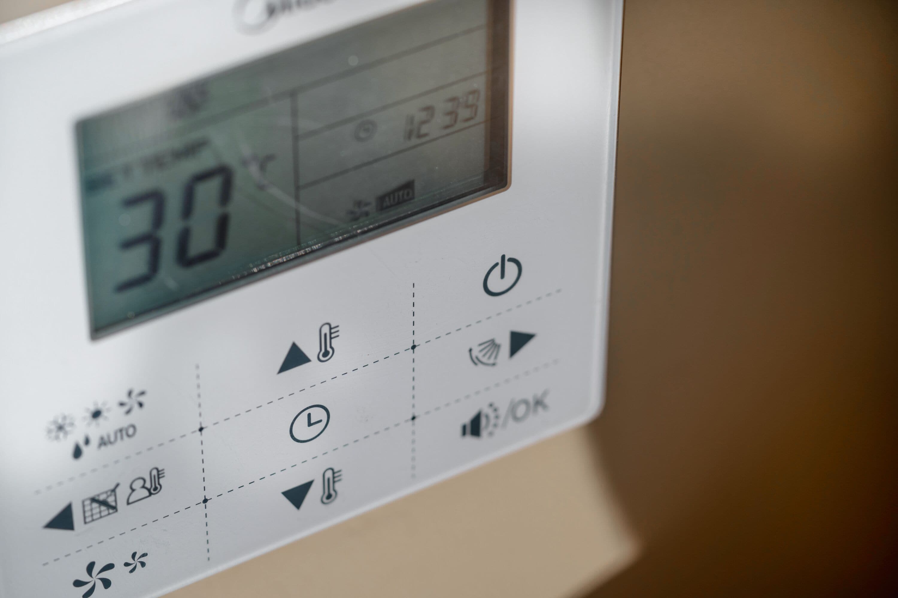 A thermostat control panel with temperature settings and icons for various functions.