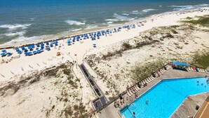 Ein Strand mit Schwimmbecken, Sonnenschirmen und Liegestühlen.