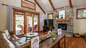A cozy living room with a stone fireplace, leather sofa, and a sign that reads "WILD & FREE". - Central Location w/ Suncadia Pool Access (Cle Elum)
