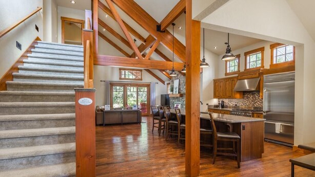 A spacious kitchen with wooden beams, a large island, and a stainless steel refrigerator. - Central Location w/ Suncadia Pool Access (Cle Elum)