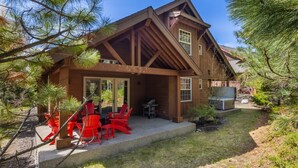 A wooden cabin with a covered patio, red chairs, and a grill. - Central Location w/ Suncadia Pool Access (Cle Elum)