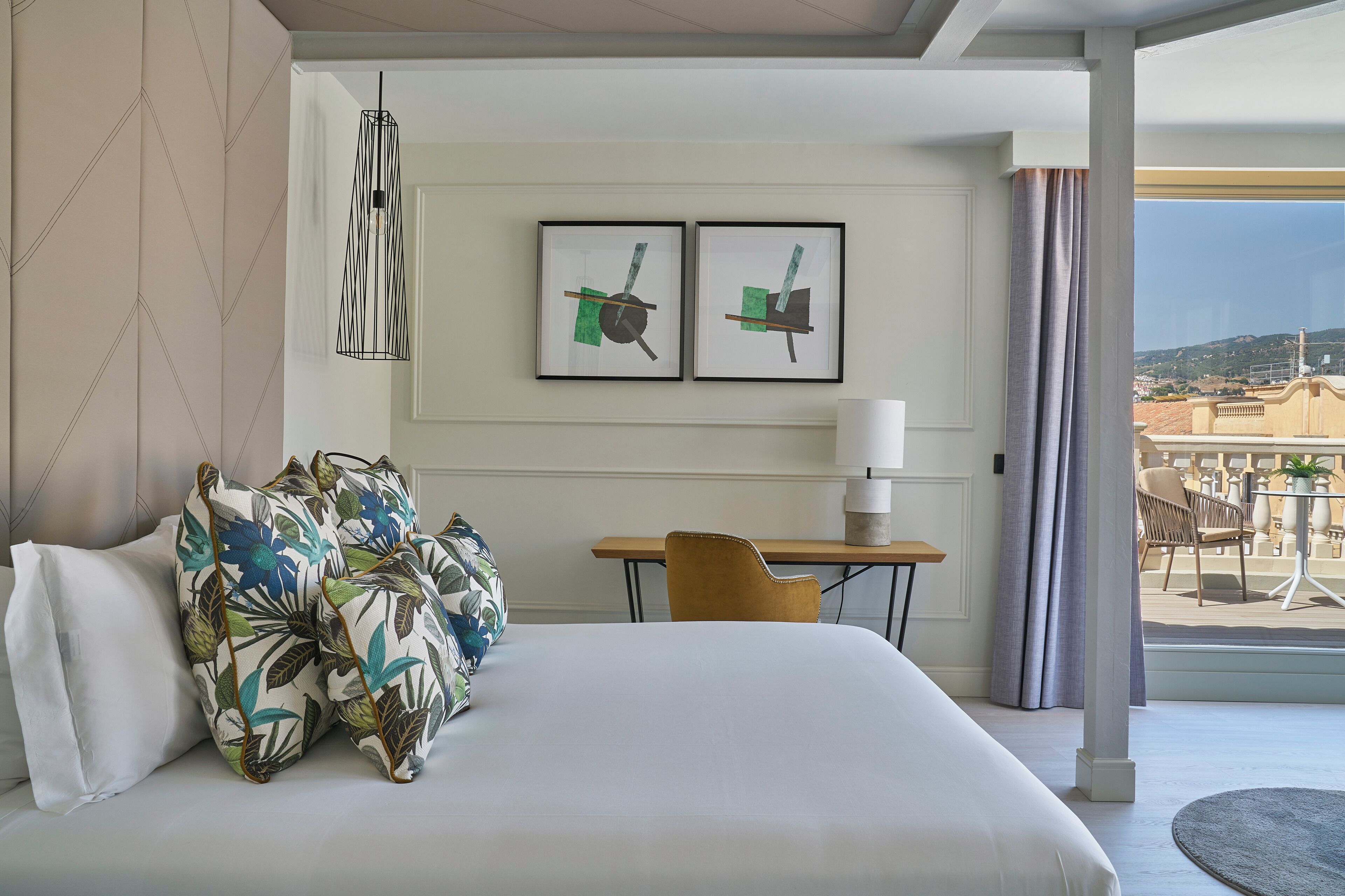 Una habitación de hotel con cama, escritorio y vistas al exterior.