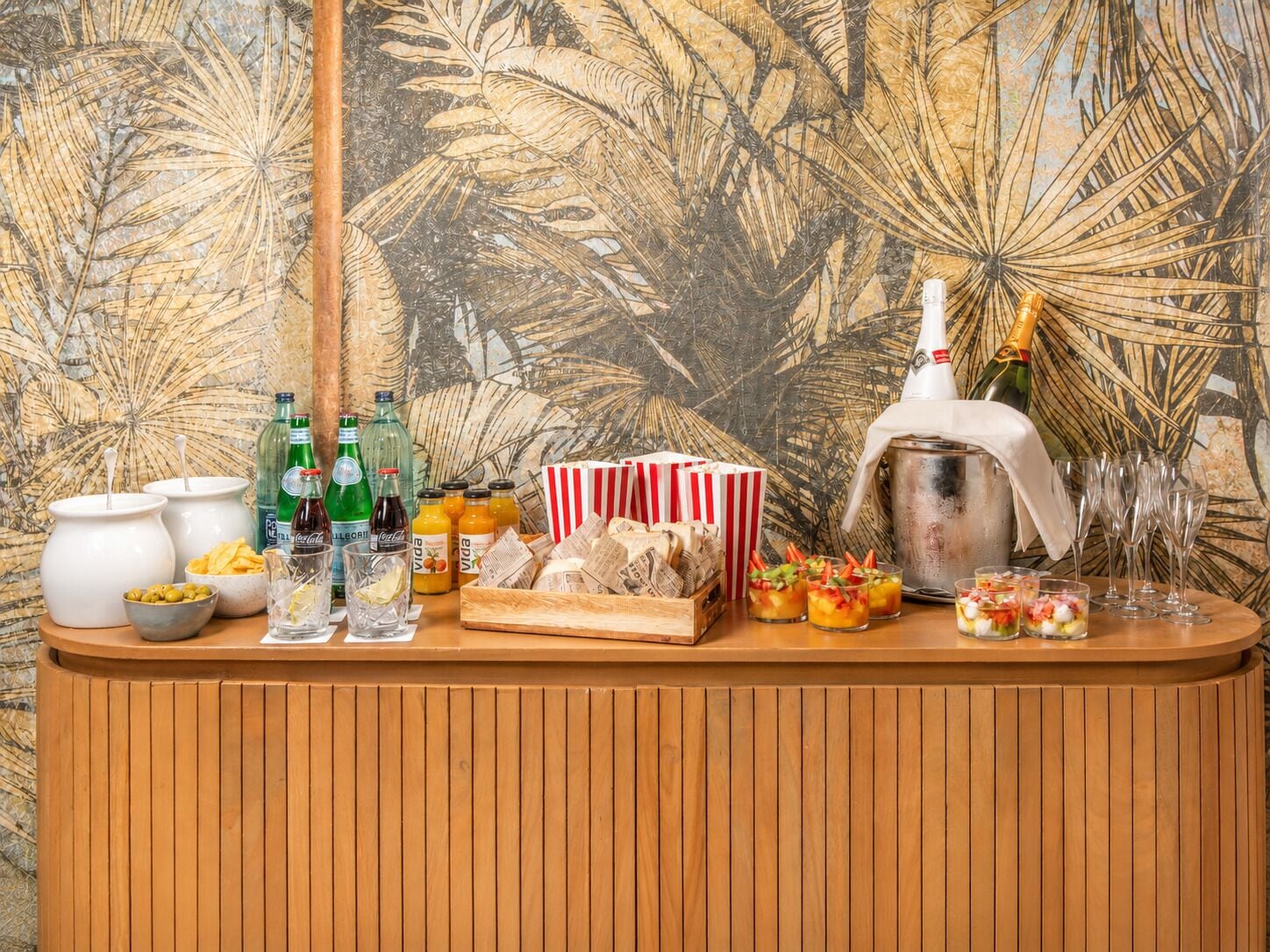 Una zona de bar con botellas, vasos y aperitivos.