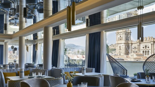 A restaurant with a view of a historic building across the street. - Hotel Vincci Larios Diez (Málaga)