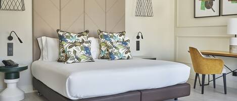 A modern hotel room with a large bed, a desk, and a chair.